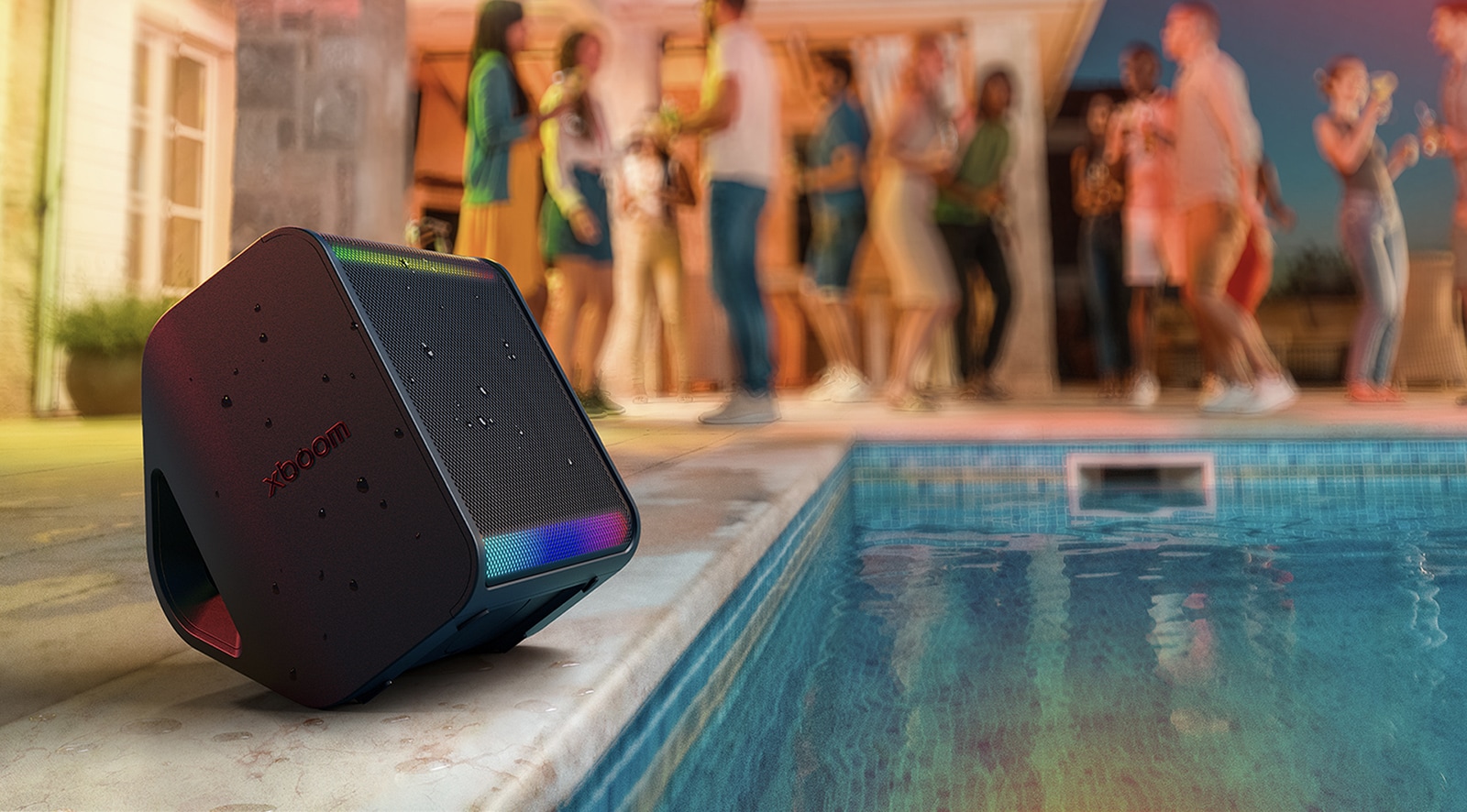 LG Xboom Stage 301 у бассейна с RGB-подсветкой, люди отдыхают на фоне