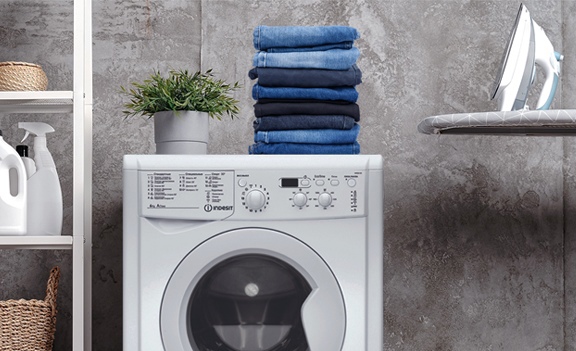 Indesit EcoTime IWSC 6105 — стиральная машина в интерьере с аккуратно сложенным чистым бельём