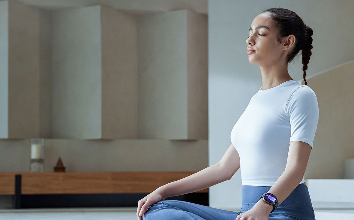 Samsung Galaxy Watch8 на запястье в медитативной позе — демонстрация носки и круглого дисплея